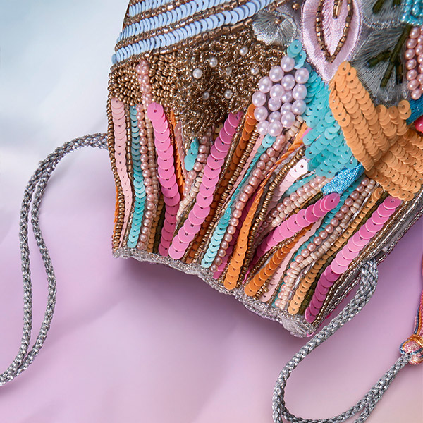 Eine kunstvoll verzierte Clutch mit farbigen Perlen, Pailletten und Stickereien setzt einen auffälligen und dekorativen Akzent.