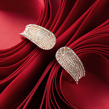 Ein glitzernder Armreif umfasst rotes Schleifenband