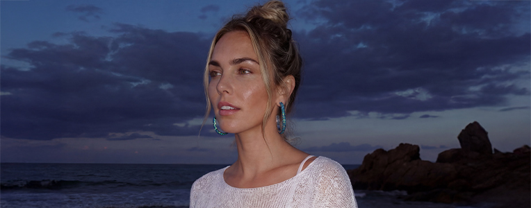 Eine Frau mit blauen, glitzernden Creolen