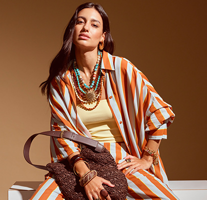 Collane di perle turchesi a più strati e ciondoli dorati completano un top a righe in un caldo stile ispirato a Marrakech.