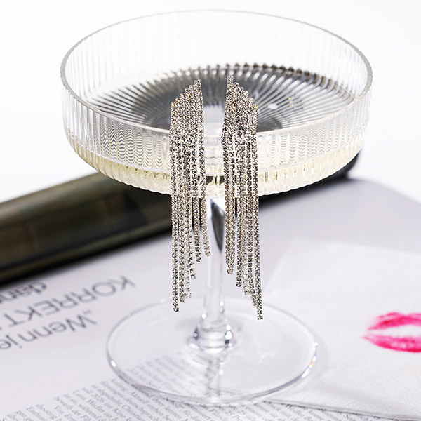 Funkelnde Ohrringe an einem Champagnerglas