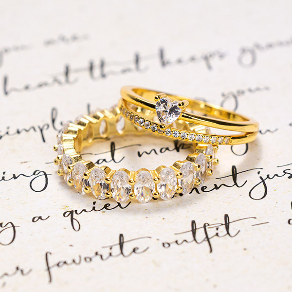 Bagues en zircone dorée sur une lettre manuscrite.