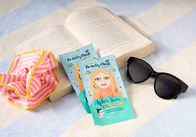Sonnenbrille, Schminkmaske, Papierkarte, Strandtuch, Buch
